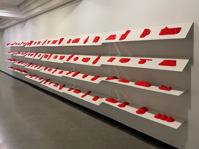 Instalación artística de Jorge Yeregui con montañas rojas en la pared