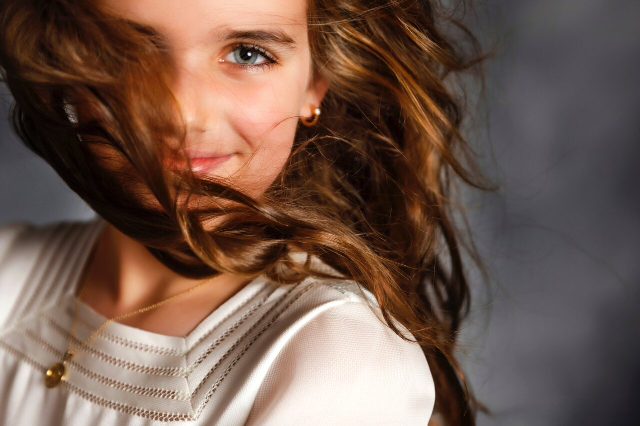 Niña con cabello largo y suelto sonriendo a la cámara