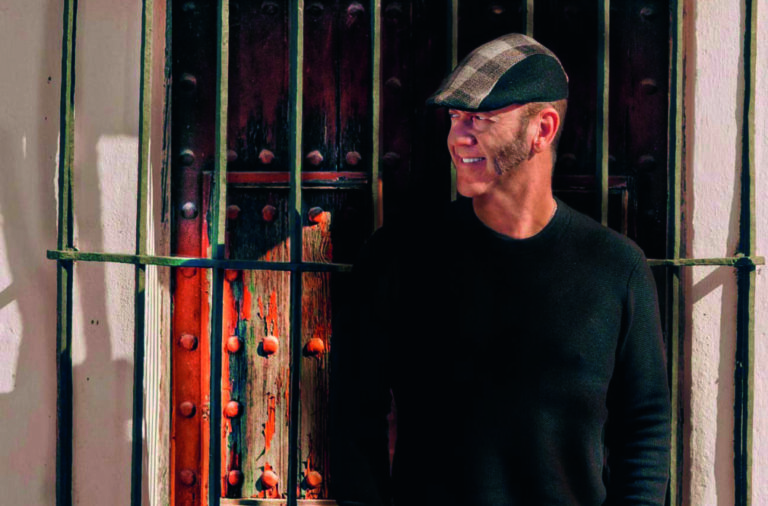 Paco Candela posando frente a una puerta antigua con rejas