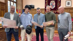 Cuatro personas sosteniendo carteles del torneo de esgrima en Palencia