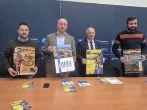 Cuatro personas sosteniendo carteles de la feria de San Sebastián en Paredes de Nava