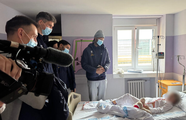 Jugadores de baloncesto visitan pacientes en el hospital con peluches.