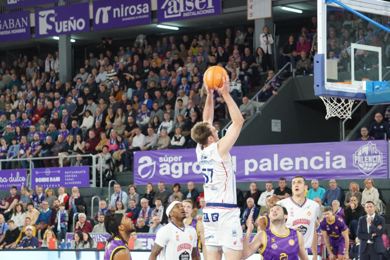 Jugador del Palencia lanzando a canasta en un partido de baloncesto