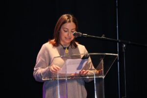 Mujer leyendo un discurso en un evento sobre convivencia y diversidad