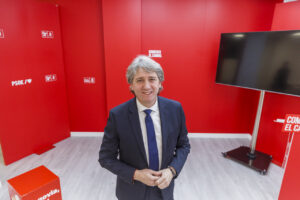 Carlos Martínez, candidato del PSOE, en un fondo rojo con logotipos del partido.