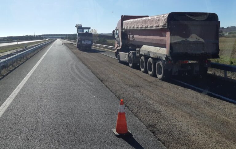 Camión trabajando en la autovía A-67 con señal de limitación de velocidad.