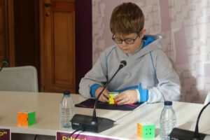Niño resolviendo un cubo de Rubik en un torneo en Palencia.