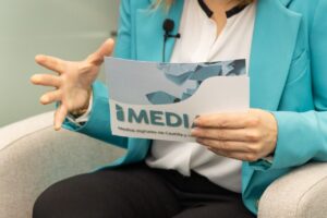 Manos de una persona sosteniendo un documento de IMEDIAcyl durante una entrevista