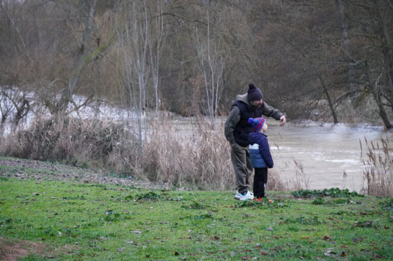 Un adulto y un niño observan el río Carrión en Palencia