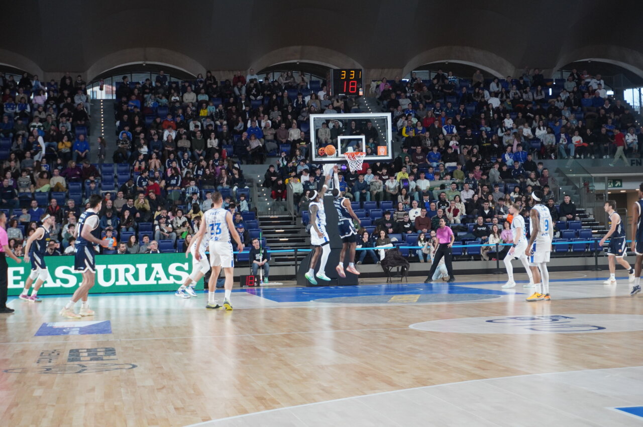 Jugadores de baloncesto en acción durante un partido en Oviedo