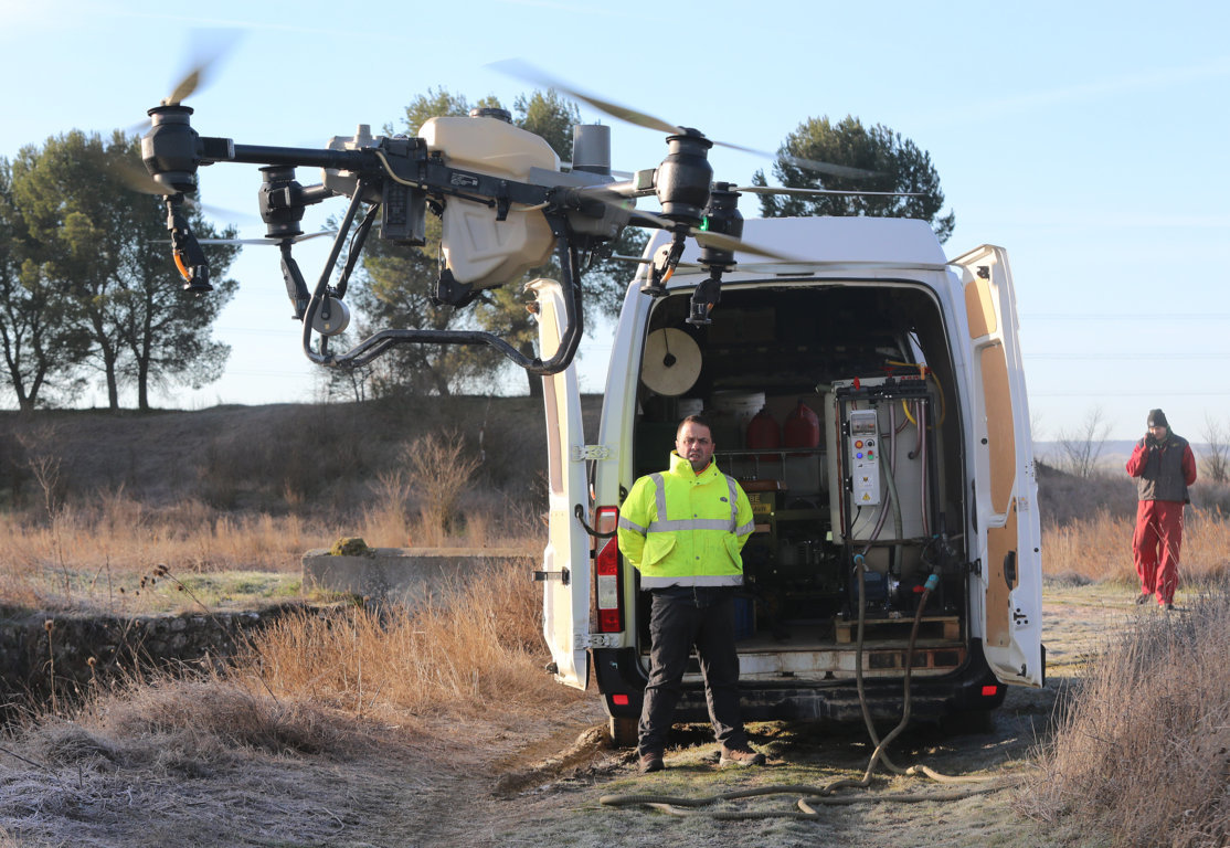Dron agrícola en acción con un operador en el campo