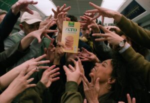 Personas en un metro alcanzando una caja de galletas Gullón Zero.