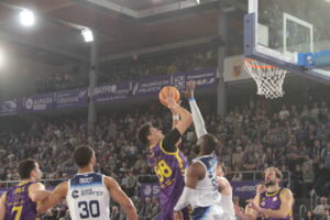Jugador del Súper Agropal Palencia lanzando a canasta durante un partido de baloncesto.