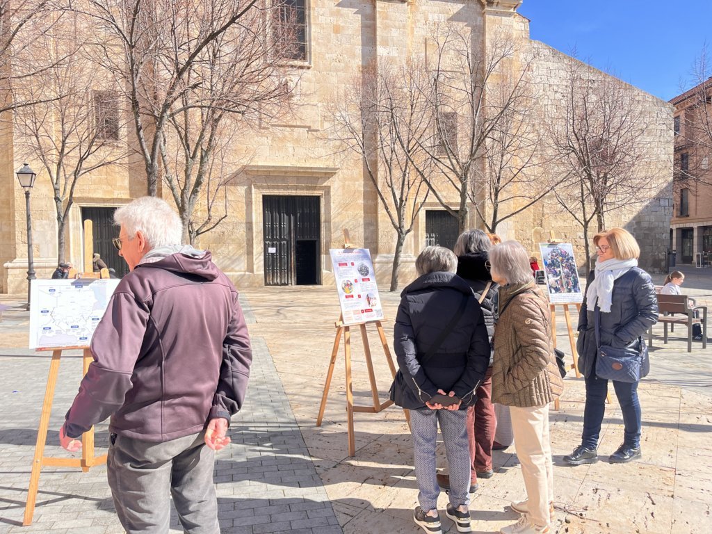 Grupo de personas observando una exposición sobre la crisis humanitaria en Sudán