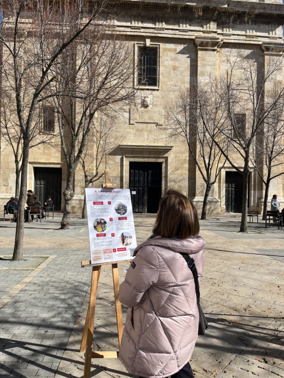 Persona observando una exposición sobre la crisis humanitaria en Sudán