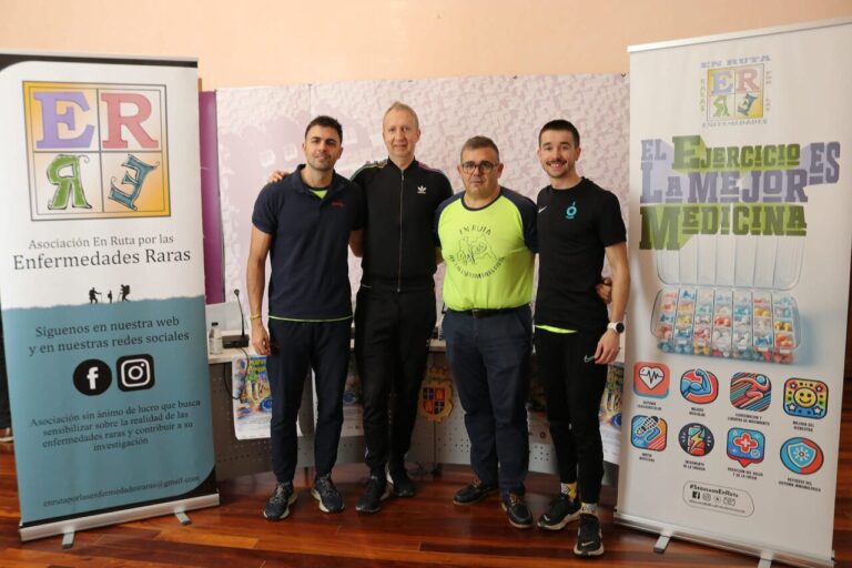 Cuatro personas posando junto a un banner sobre enfermedades raras