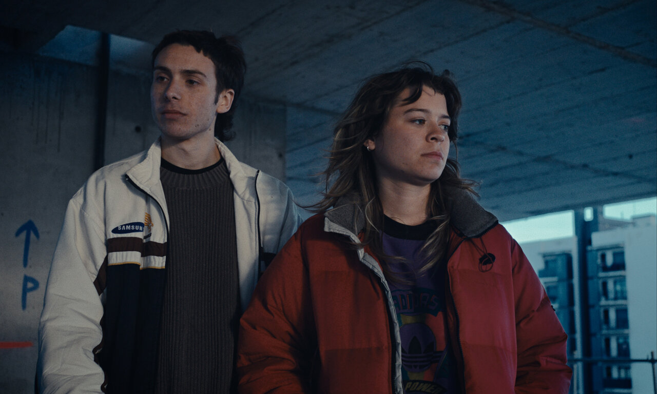 Pareja adolescente en un edificio en construcción soñando su futuro.