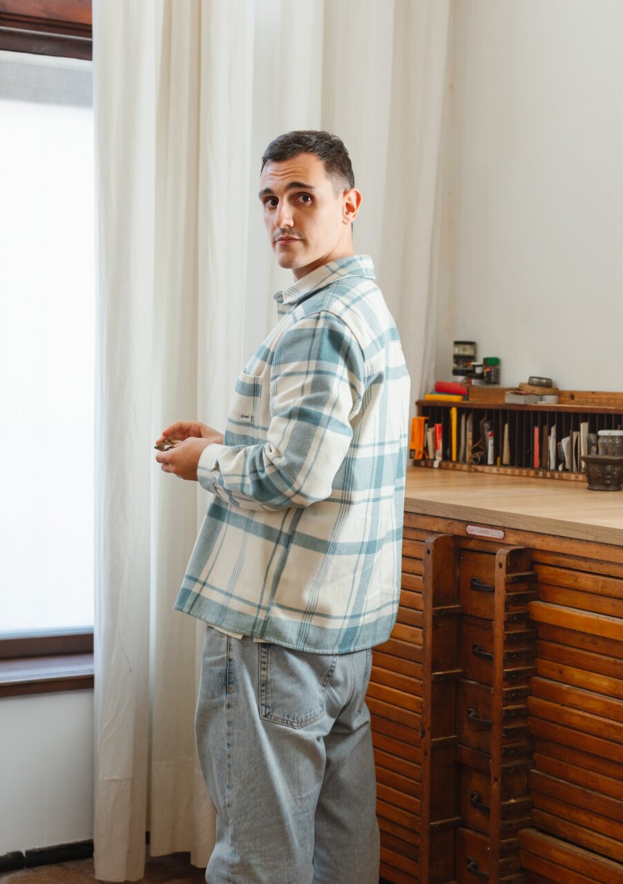 Daniel Iglesias, diseñador gráfico, sosteniendo un objeto en su estudio.