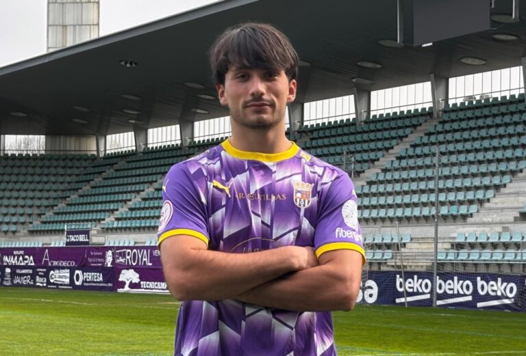 David Vallecillo posando en el estadio con uniforme de fútbol morado