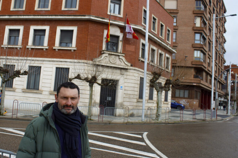 Hombre frente a un edificio con banderas en Palencia