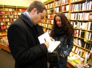Javier Sierra firmando un libro a una lectora en una librería