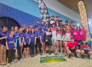 Grupo de jóvenes del Club Deportivo Oca SOS en la piscina tras ganar un trofeo