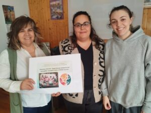 Tres mujeres sosteniendo un cartel con donativo de sopas de ajo