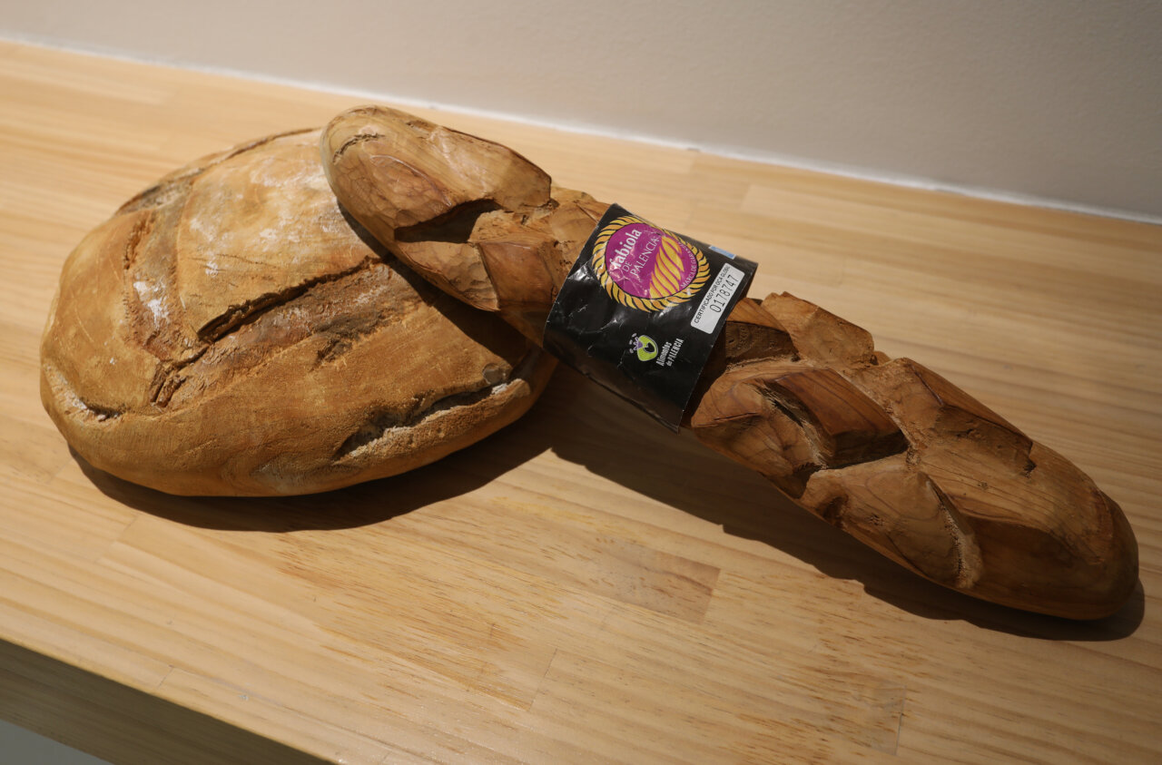 Escultura de madera que representa un pan y una baguette tallados a mano.