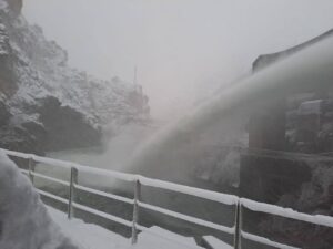 Vista de una estación fluvial con nieve y agua desbordando