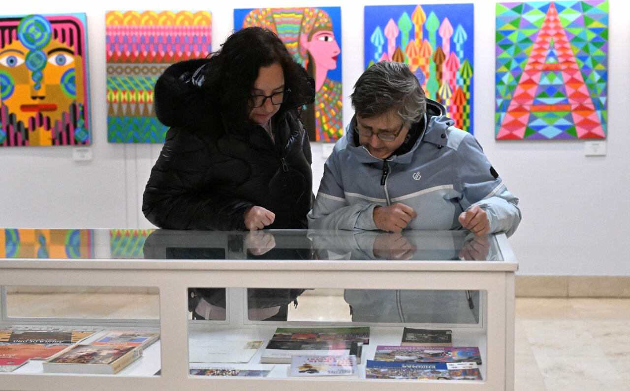 Visitantes observando obras en la exposición de Ramón Margareto