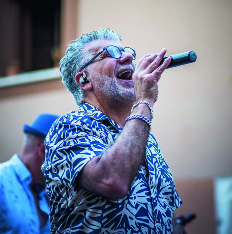 Heber Mota cantando en un concierto con micrófono en mano