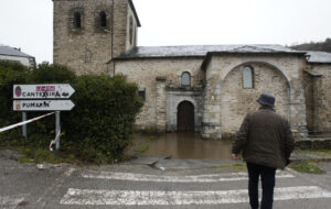 Hombre caminando hacia una iglesia inundada en Palencia