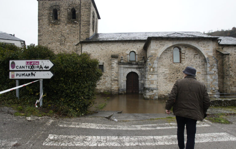 Hombre caminando hacia una iglesia inundada en Palencia