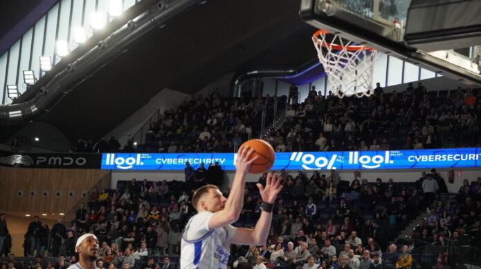 Jugador lanzando a canasta en un partido de baloncesto