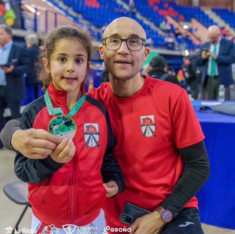 Oliver Medina Laso con medalla y entrenador en evento deportivo