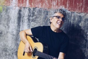 Pedro Guerra tocando la guitarra en el Teatro Principal de Palencia