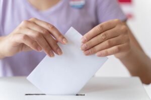 Una persona colocando su voto en una urna electoral