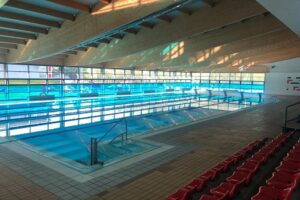 Vista interior de la piscina municipal Campos Góticos con asientos vacíos