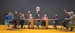 Participantes levantando la mano en una reunión