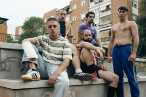 Grupo de jóvenes sentados en un banco en un entorno urbano