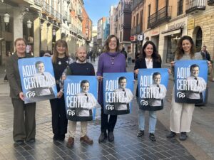 Miembros del PP sosteniendo carteles de campaña en Palencia