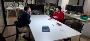 Eduardo Velázquez discutiendo con un colega en una oficina moderna