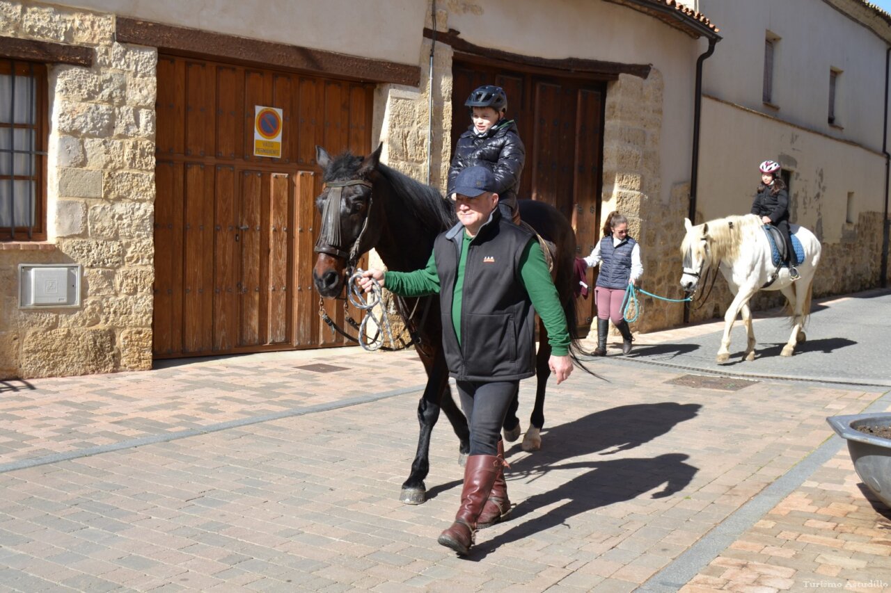 Personas montando a caballo en una calle de Astudillo