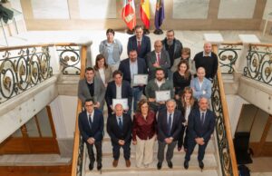 Grupo de personas posando con certificados en un evento de premiación