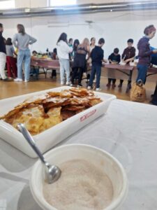 Taller de elaboración de orejuelas en Husillos con participantes de diversas edades.