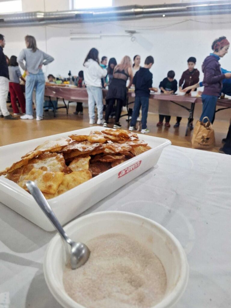 Taller de elaboración de orejuelas en Husillos con participantes de diversas edades.