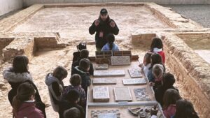 Grupo de escolares en un taller de mosaico romano en La Olmeda