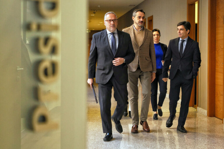 Grupo de personas caminando en un pasillo durante un evento político