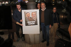 Grupo de personas sosteniendo un cartel de Vox en una manifestación