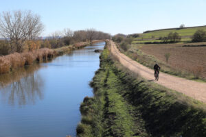 Ciclista recorriendo el Canal de Castilla en un día soleado